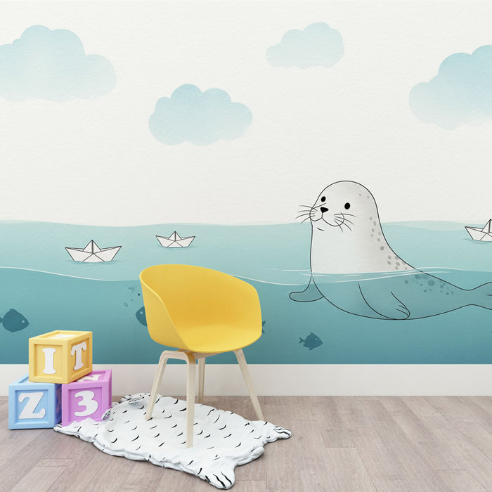 Une chambre d'enfant avec un papier peint illustratif représentant une otarie nageant dans une mer turquoise, entourée de nuages doux et de petits bateaux en papier, créant une atmosphère ludique et apaisante.