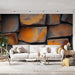 Papier peint mural effet pierre avec nuances orange et grises pour salon moderne