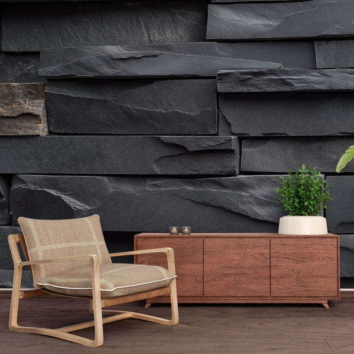 Une pièce moderne avec un papier peint imitant des murs en pierre noire texturée, créant une ambiance à la fois élégante et chaleureuse.