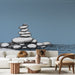 Un salon moderne avec un papier peint représentant des pierres empilées sur un fond bleu apaisant, créant une atmosphère zen et sereine.