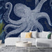 Un salon moderne avec un papier peint représentant un poulpe stylisé en blanc sur fond bleu marine, créant une ambiance marine et artistique.
