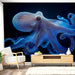 Un salon moderne avec un papier peint représentant un poulpe bleu vibrant sur fond noir, créant une ambiance artistique et intrigante.