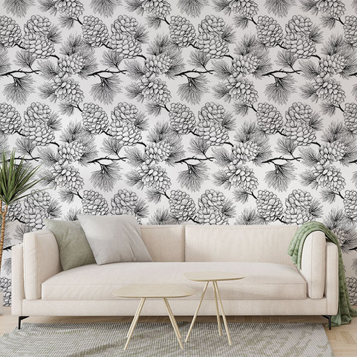 Un salon moderne avec un papier peint noir et blanc illustrant des pommes de pin et des branches, créant une atmosphère naturelle et élégante.