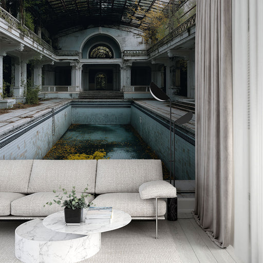 Un salon contemporain avec un papier peint représentant une piscine abandonnée, aux teintes froides et mélancoliques, évoquant une atmosphère nostalgique et mystérieuse.