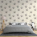Une chambre apaisante avec un papier peint floral représentant des pissenlits en noir sur fond crème, créant une atmosphère douce et naturelle.