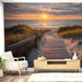 Une pièce moderne avec un papier peint représentant un chemin de planches menant à la plage au coucher de soleil, créant une ambiance sereine et apaisante.