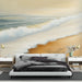 Une chambre apaisante avec un papier peint représentant une plage dorée et des vagues douces, évoquant une ambiance sereine et relaxante.