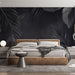 Une chambre moderne avec un papier peint noir orné de grandes feuilles tropicales grises, créant une atmosphère élégante et apaisante.