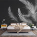 Une chambre moderne avec un papier peint noir orné de grandes plumes blanches, créant une atmosphère élégante et apaisante.