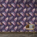 Une pièce élégante avec un papier peint aux motifs de plumes colorées sur fond violet, créant une atmosphère artistique et chaleureuse.