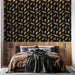 Une chambre moderne avec un papier peint noir orné de feuilles dorées et argentées, créant une ambiance élégante et chaleureuse.