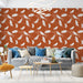 Un salon moderne avec un papier peint terracotta orné de plumes blanches sur fond texturé, créant une ambiance chaleureuse et accueillante.