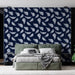 Une chambre moderne avec un papier peint bleu nuit orné de plumes blanches, créant une atmosphère apaisante et élégante.