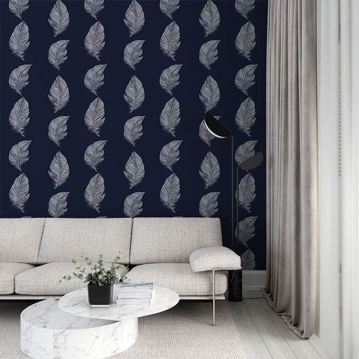 Un salon moderne avec un papier peint bleu nuit orné de délicates feuilles blanches, créant une atmosphère élégante et apaisante.