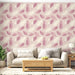 Un salon lumineux avec un papier peint floral aux motifs de plumes dans des teintes rose et crème, créant une atmosphère douce et apaisante.