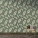 Une pièce moderne avec un papier peint vert olive orné de délicates plumes blanches, créant une atmosphère apaisante et naturelle.