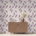 Une salle à manger moderne avec un papier peint aux motifs de plumes violettes sur fond clair, créant une ambiance douce et élégante.