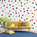 Un salon moderne avec un papier peint ludique orné de ronds colorés sur fond blanc, créant une atmosphère joyeuse et dynamique.