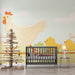 Une chambre d'enfant avec un papier peint illustré représentant une grande poule et des poussins jaunes sur fond pastel, créant une ambiance ludique et chaleureuse.