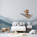 Une chambre d'enfant avec un papier peint illustratif représentant un renard volant en papier sur un fond de montagnes douces, créant une atmosphère ludique et imaginative.