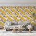 Un salon lumineux avec un papier peint floral aux roses jaunes éclatantes sur fond crème, créant une ambiance chaleureuse et accueillante.