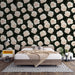 Une chambre moderne avec un papier peint floral représentant de grandes roses blanches sur fond noir, créant une ambiance élégante et romantique.