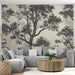 Un salon moderne avec un papier peint représentant des arbres en noir et blanc sur fond beige, créant une atmosphère élégante et apaisante.