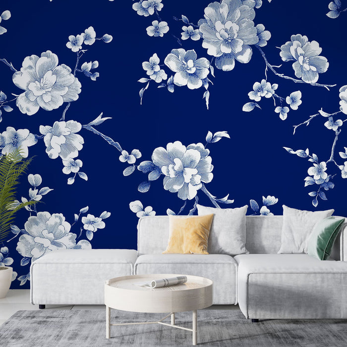 Un salon moderne avec un papier peint floral bleu nuit et blanc représentant des fleurs délicates, créant une atmosphère élégante et apaisante.