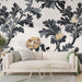 Un salon élégant avec un papier peint floral aux motifs noirs, gris et dorés sur fond clair, créant une ambiance sophistiquée et chaleureuse.