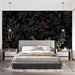 Une chambre moderne avec un papier peint floral noir aux motifs de feuilles et fleurs dans des teintes rouges et beiges, créant une ambiance élégante et chaleureuse.