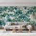 Un salon moderne avec un papier peint botanique aux motifs de feuillage luxuriant dans des teintes de vert et blanc, créant une atmosphère apaisante et naturelle.