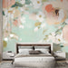 Une chambre moderne avec un papier peint floral aux grandes fleurs pastel sur fond vert doux, créant une atmosphère apaisante et romantique.