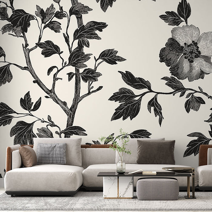 Un salon contemporain avec un papier peint floral noir et blanc représentant des branches et des fleurs, créant une ambiance élégante et artistique.