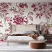 Une chambre élégante avec un papier peint floral rouge profond sur fond clair, créant une atmosphère romantique et chaleureuse.