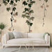 Un salon moderne avec un papier peint floral beige illustrant des lianes vertes et des fleurs délicates, créant une ambiance apaisante et naturelle.