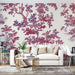 Un salon élégant avec un papier peint floral aux motifs de branches et feuilles en rouge et violet sur fond clair, créant une atmosphère chaleureuse et artistique.