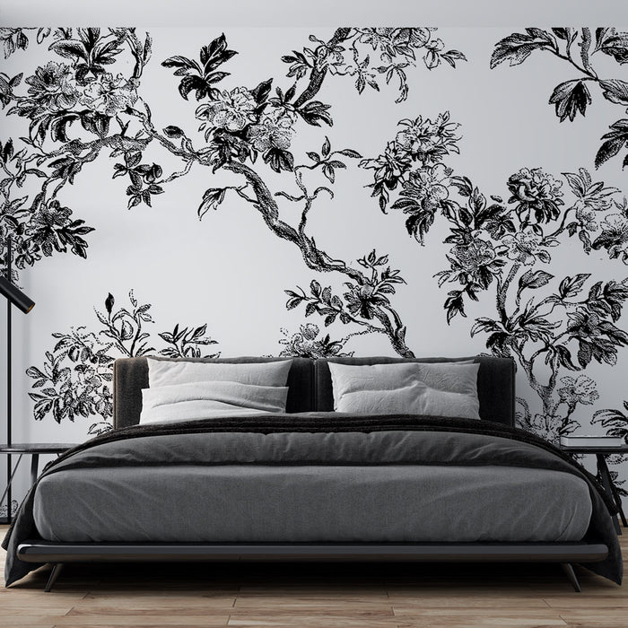 Une chambre moderne avec un papier peint floral noir et blanc représentant des branches et des fleurs, créant une ambiance élégante et artistique.