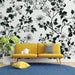 Un salon contemporain avec un papier peint floral noir et blanc représentant des fleurs et des feuilles, créant une atmosphère élégante et apaisante.