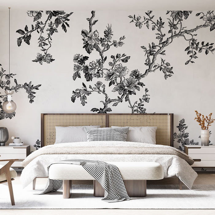 Une chambre élégante avec un papier peint floral noir et blanc présentant des branches délicates et des fleurs, créant une ambiance artistique et apaisante.