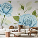 Un salon moderne avec un papier peint floral représentant de grandes roses bleues et des feuilles vertes, créant une ambiance douce et apaisante.