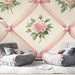 Une chambre élégante avec un papier peint à motifs de roses roses entourées de rubans délicats sur fond crème, créant une atmosphère romantique et chaleureuse.