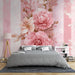 Une chambre élégante avec un papier peint floral aux roses roses délicates sur fond de rayures pastel, créant une ambiance douce et romantique.