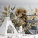 Une chambre d'enfant avec un papier peint illustrant un singe endormi entouré de feuilles aux teintes douces, créant une atmosphère chaleureuse et apaisante.