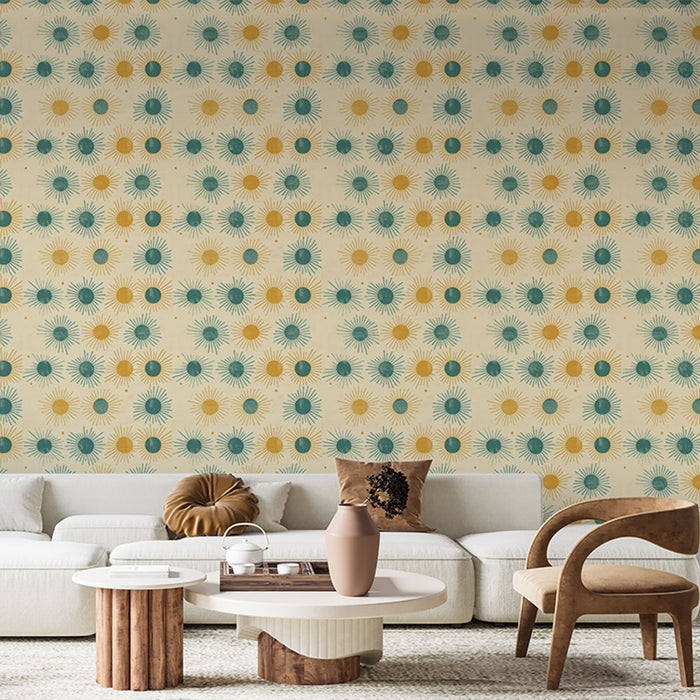 Un salon lumineux avec un papier peint aux motifs de soleils jaunes et bleus sur fond crème, créant une ambiance joyeuse et chaleureuse.