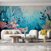 Un salon moderne avec un papier peint aquatique aux teintes bleues et corail, représentant des plantes marines stylisées et créant une atmosphère apaisante et rafraîchissante.