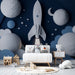 Papier peint spatial avec fusée et planètes en relief sur fond bleu pour chambre d'enfant.