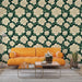 Un salon moderne avec un papier peint floral représentant de grandes fleurs blanches sur fond vert foncé, créant une atmosphère fraîche et apaisante.