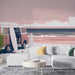 Une pièce de vie moderne avec un papier peint illustrant un van vintage rose sur une plage, évoquant une ambiance estivale et décontractée.