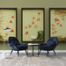 Un salon moderne avec un papier peint aux motifs de feuilles de ginkgo dans des teintes orange sur un fond vert doux, créant une atmosphère chaleureuse et apaisante.