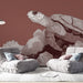 Une salle de séjour moderne avec un papier peint représentant une tortue stylisée sur fond rouge, créant une ambiance artistique et apaisante.